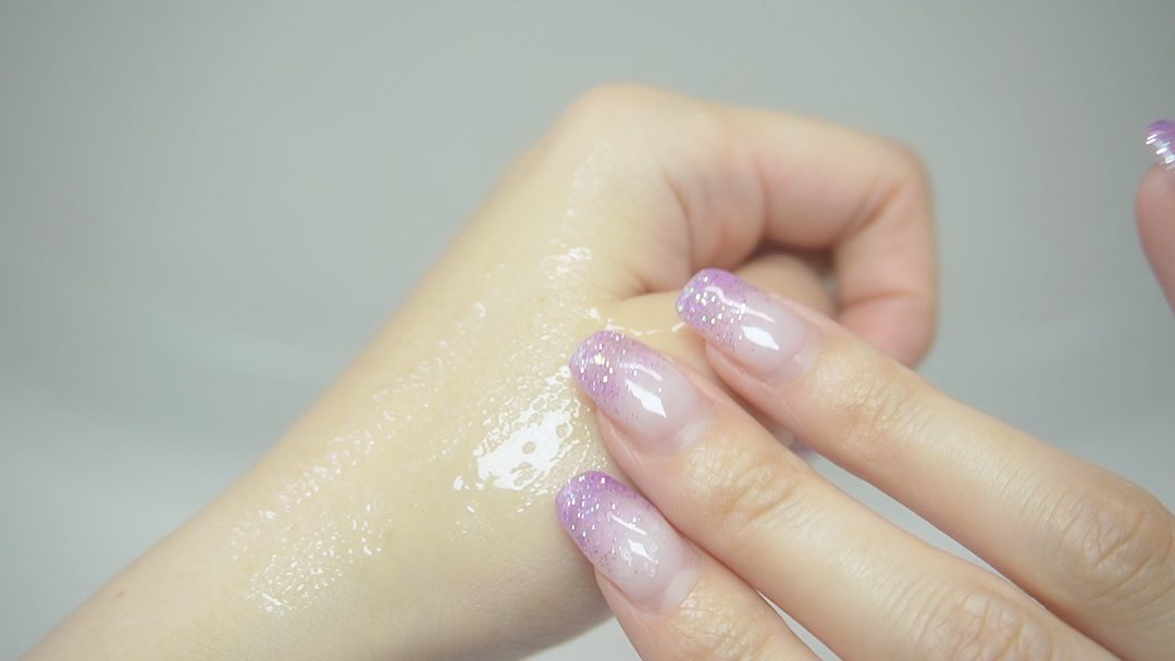 指で美容液を手の甲に伸ばしている途中