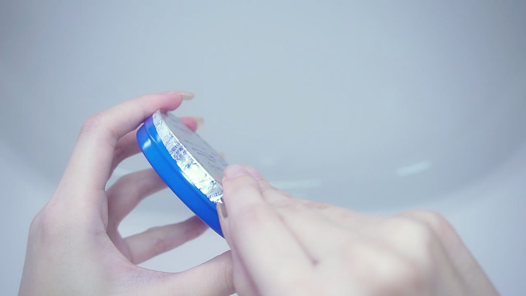 だるま缶を開けて内側のアルミシールをはがすところ