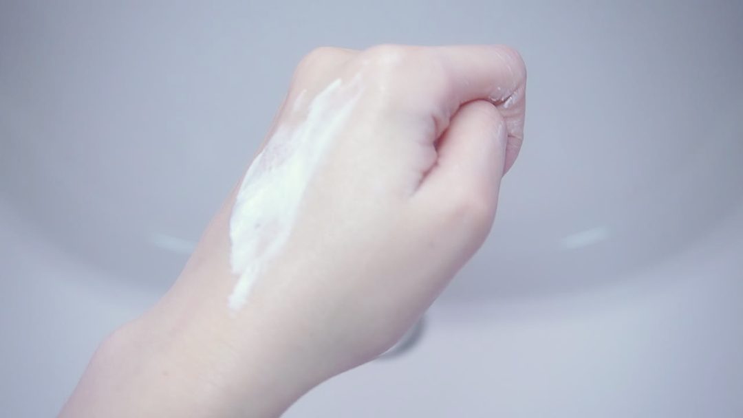 手の甲でニベアクリームを伸ばしている途中の白っぽく残る様子