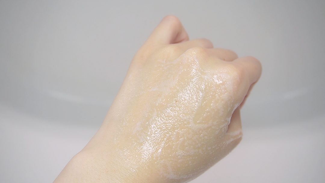 泡を伸ばしている途中の手の甲。泡が消えてツヤが出てきている